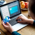 man feeding his credit card info into his laptop